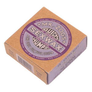 Shapers-Club- Une boîte carrée en carton contenant « Sexwax - Cold » dans une formule extra douce à basse température. La boîte beige comporte des étiquettes violettes et noires avec un texte et une marque clairs. Ce produit non toxique pèse 85 grammes. -surfshop-surfboard
