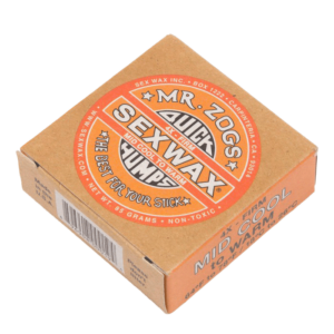 Shapers-Club- L'image présente une boîte orange de 85 g de Sexwax de M. Zog, étiquetée « Quick Humps », « Warm Tropical » et « The Best For Your Stick », conçue pour les planches de surf dans des conditions moyennement fraîches à chaudes. -surfshop-surfboard