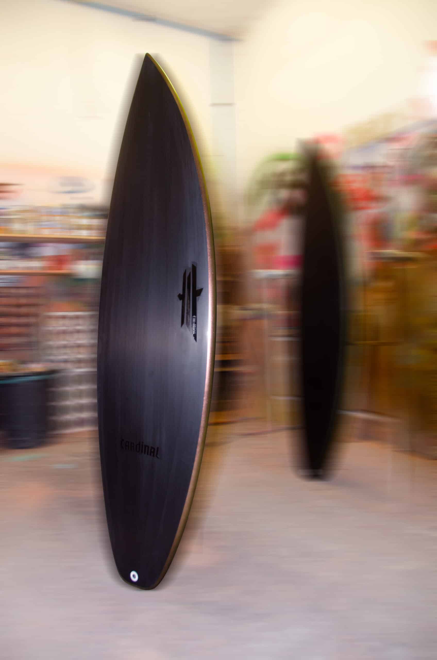 Shapers-Club- A sleek, shiny Fire Arrow surfboard stands tall inside, its design accentuating its charm. A fuzzy surfboard in the room's vibrant decor adds charm. Measuring 5'9" x 19' 1/4" x 2' 1/2", it promises an exhilarating ride. -surfshop-surfboard
